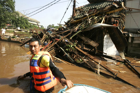 Burst dam in Indonesia: A rescuer searches for flood victims on the outskirts of Jakarta