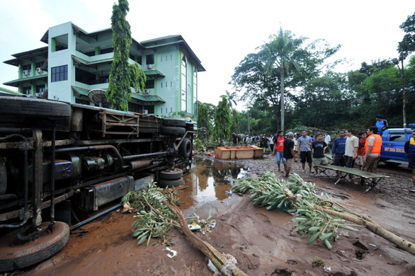 Burst dam in Indonesia: Volounteers check out the damage done near the University of Muhammadiyah