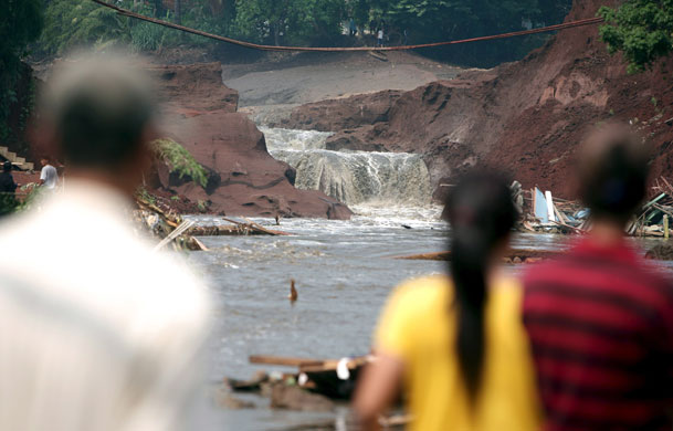 Burst dam in Indonesia: Residents look at the burst dam