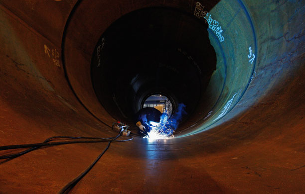 27 March 2009: Welders work on tower sections of a wind turbine at Skyton's plant