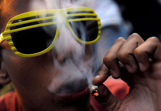 27 March 2009: Medellin, Colombia: A man smokes a marijuana joint during a protest 