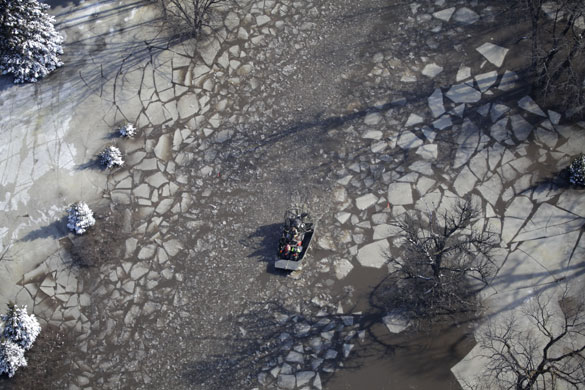 24 hours in pictures: Fargo, North Dakota, USA: A rescue airboat moves down a flooded icy road