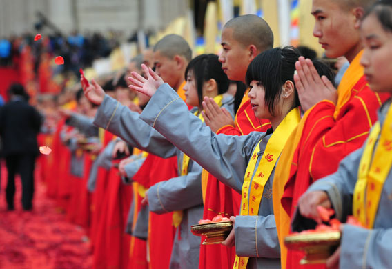 24 hours in pictures: Wuxi, China: Volunteers toss rose petals at the World Buddhist Forum. 