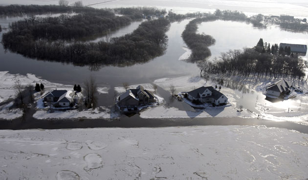 Red River floods: Homes are surrounded by floating ice and floodwater as the Red River rises.