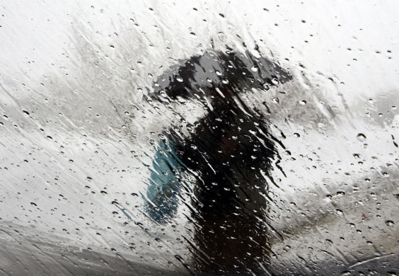 3 March 2009: Kabul, Afghanistan: A man walking with an umbrella in the rain