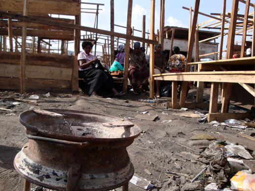 Owino market fire: People sit the remains of stalls after a fire in market, Kampala, Uganda.