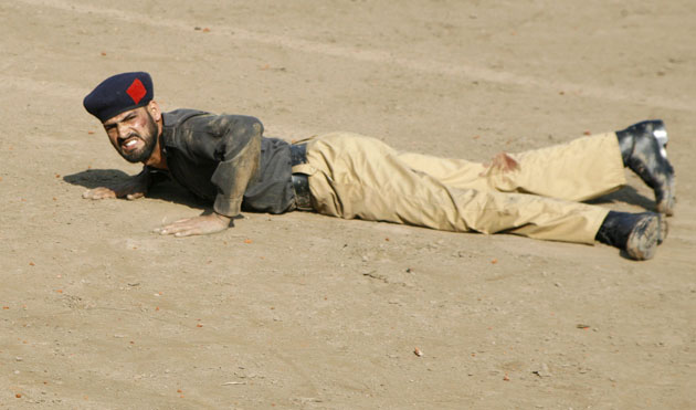Siege in Lahore: An injured policeman looks for assistance at the site of a shooting.