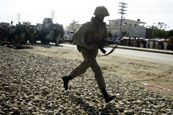 Siege in Lahore: A paramilitary soldier charges towards the site of a shooting.