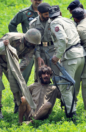 Siege in Lahore: Pakistani paramilitary soldiers arrest a suspected militant 