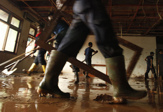 24 hours in pictures: clean up operation followin Indonesia dam burst