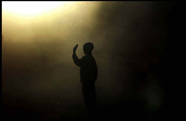 Unseen: A boy waves at Bob Geldof from a cloud of dust in northern Ethiopia