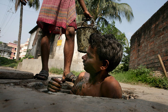 24 hours : A worker  tries to enter a sanitary manhole in in Kolkata, India