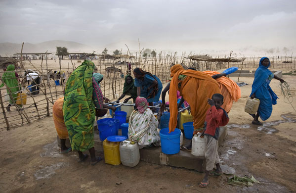 Darfur atrocities: Refugees from Darfur gather water at a well in eastern Chad.