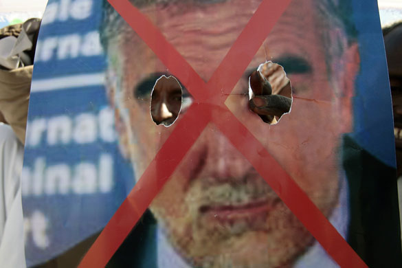 Darfur atrocities: A supporter of Sudan's President Bashir holds poster of ICC's Luis Ocampo.