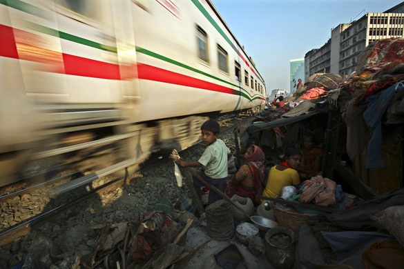 Business week: A family takes shelter in their home next to a railway track in Bangladesh