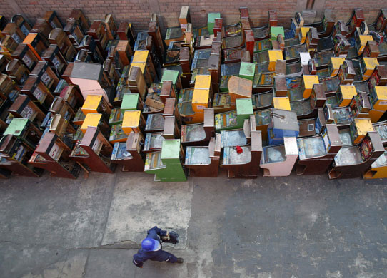 1 April 2009: Lima, Peru: A worker walks past near illegal slot machines