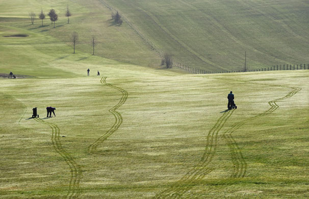 24sport: Golfers leave trails in the morning dew 