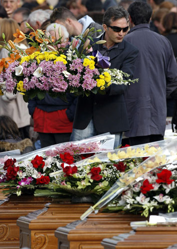 Italy earthquake funerals: A man carries a bouquet of flowers during the state funeral.