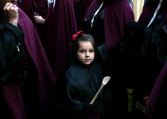24 hours in pictures: Palma de Mallorca, Spain: A girl wearing a penitent suit 