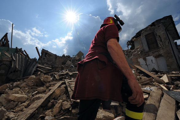24 hours in pictures: Villa Sant'Angelo, Italy: A firefighter passes rubble of a collapsed church