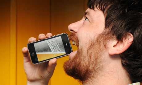 A man with a Carling iPint virtual lager app on an iPhone