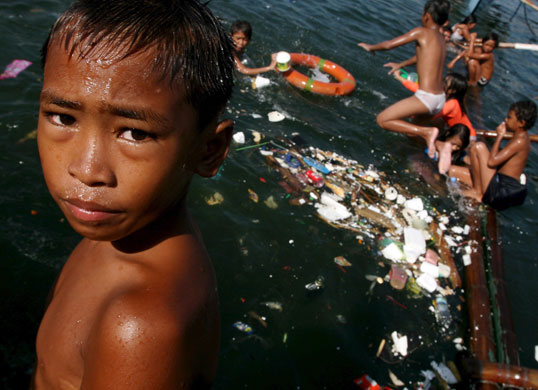 24 hours in pictures: Manila, Philippines: Filipino children in the polluted waters of the bay.