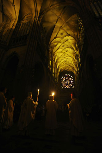 24 hours in pictures: Prague, Czech Republic: Priests hold candles in St Vitus Cathedral 