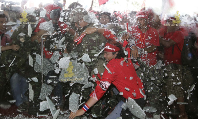 24 hours in pictures: Supporters of Thai PM Thaksin as a glass door shatters at ASEAN Summit.