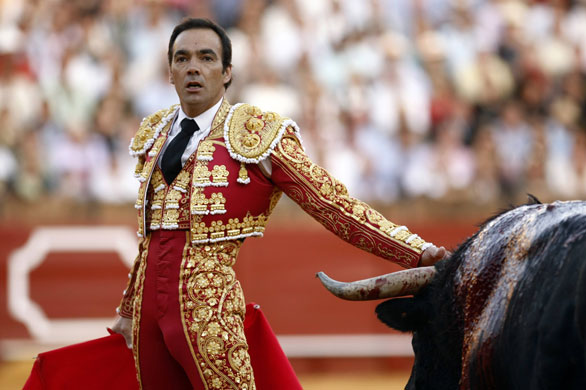 Bullfight season starts: ullfighter Manuel Jesus looks at the crowd next to a bull