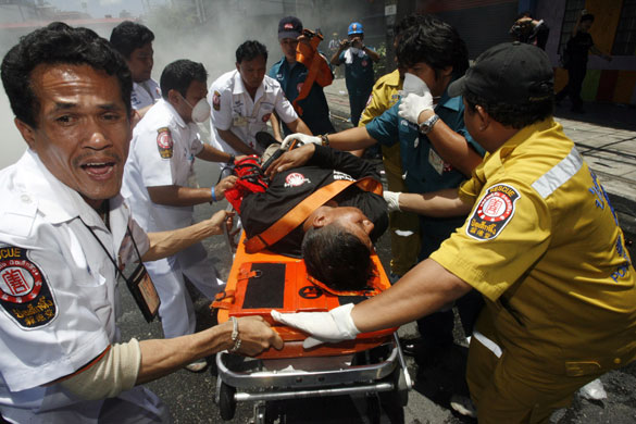 Thailand protests: Medical workers transport an injured supporter of ousted Thai PM.