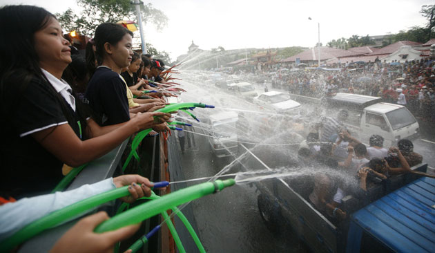 Burma water festival: Festival goers spray water on passersby celebrating Thingyan