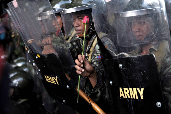 14 April 2009: Bangkok: A soldier holds a rose gievn by a supporter of Thaksin Shinawatra