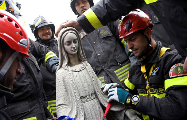 14 April 2009: Paganica: Firemen remove the marble statue of Madonna from the church