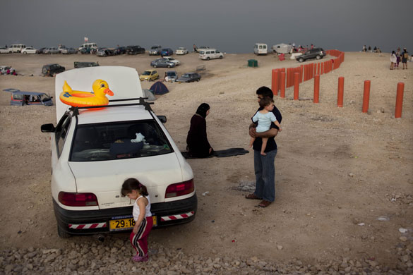 14 April 2009: Dead Sea, Israel: A Muslim family gather around their car on the beach