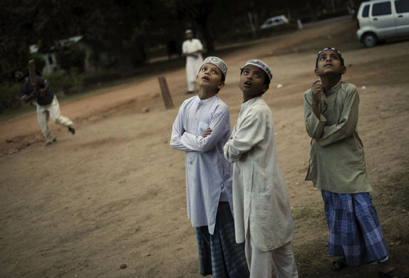 14 April 2009: New Delhi, India: Boys watch a game of cricket