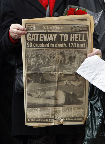 Hillsborough memorial: A mourner with a newspaper from the day after the Hillsborough tragedy