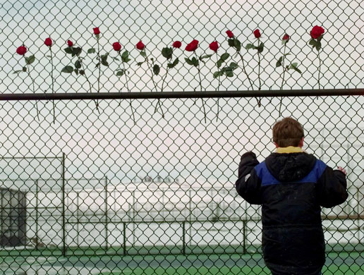 Columbine shootings: A boy looks through the fence at the Columbine High School tennis courts