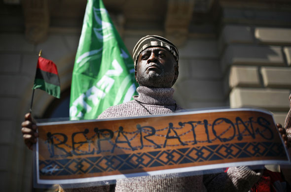24 hours in pictures: Geneva, Switzerland: An African man holds up the Pan-African flag.