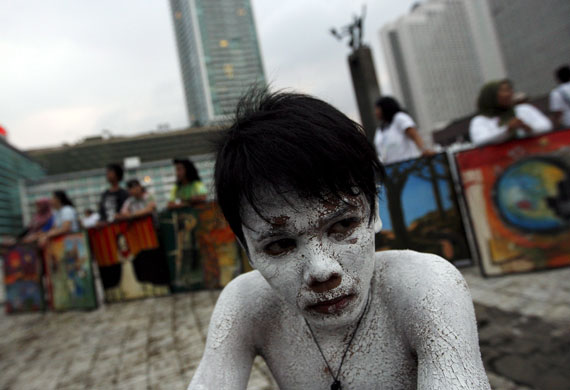 24 hours in pictures: Jakarta, Indonesia: An activist wearing body paint performs for earth day.