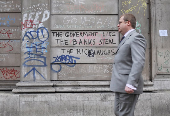 G20 protests day two: A city worker walks past graffiti on the walls of the Bank of England.