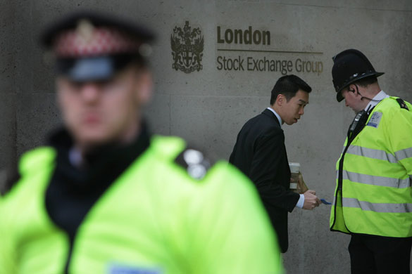 G20 protests day two: A police officer checks a man's ID outside the London Stock Exchange