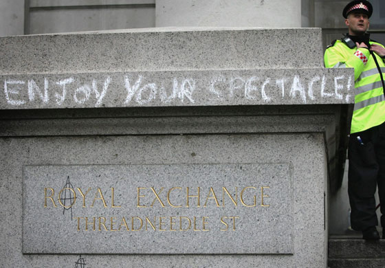 G20 protests day two: A police officer stands besides graffiti near the Bank of England.