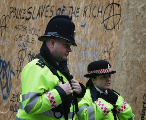 G20 protests day two: Police officers stand beside a graffiti adorned wall