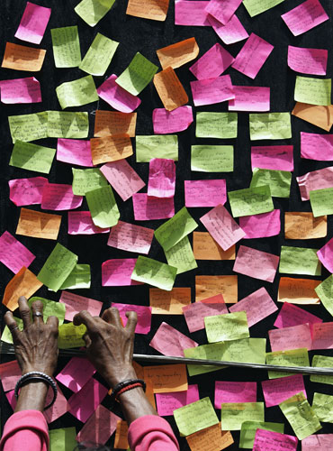 2 April 2009: Manila, Philippines: A woman places her wish notes on a giant cross