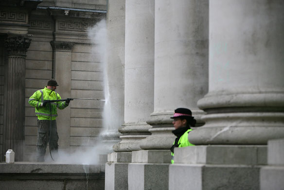 G20 protests day two: A contractor cleans graffiti from a column at The Royal Exchange building