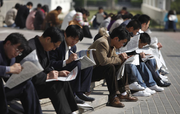 Week in Business: Job seekers look through leaflets at a job fair in Beijing, China