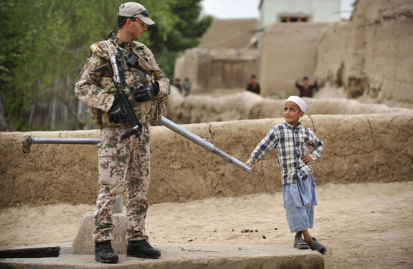 24 hours in pictures: A Afghan boy looks at a German armed forces near Kunduz