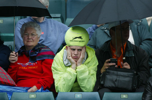 Wimbledon new roof: Tennis fans sit in the drizzling rain as they wait for Tim Henman in 2003.