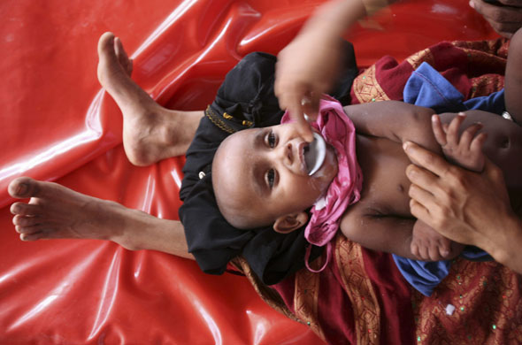 24 hours in pictures: Dhaka, Bangladesh: A mother feeds oral saline to her baby at a hospital 