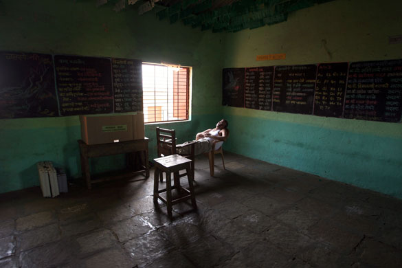 24 hours in pictures: An election official takes rest in 